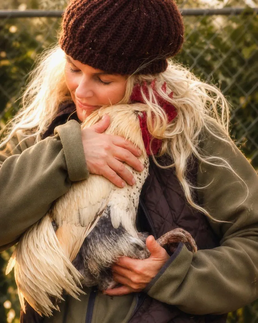 Angelique met een haan in haar armen